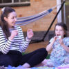 French Classes for Toddlers: French teacher with a 3-year-old girl learning French, enjoying educational activities outdoors.